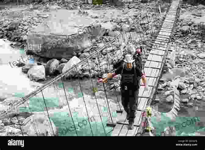 A Group Of Trekkers Crossing A Suspension Bridge Over A Roaring River In The Himalayas During The Sar Pass Trek With YHAI. THE SAR PASS TREK: At Himalaya With YHAI